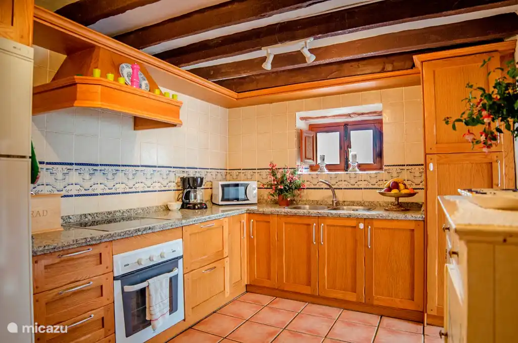 De keuken van de kleinere woning met een klein eethoekje in de keuken. En een grotere eetkamer ernaast.