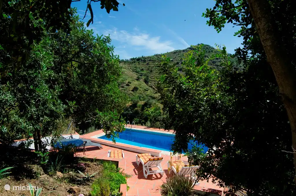 Via een trap aan het terras, wat langs de lagere woning loopt, kom je bij het privézwembad.