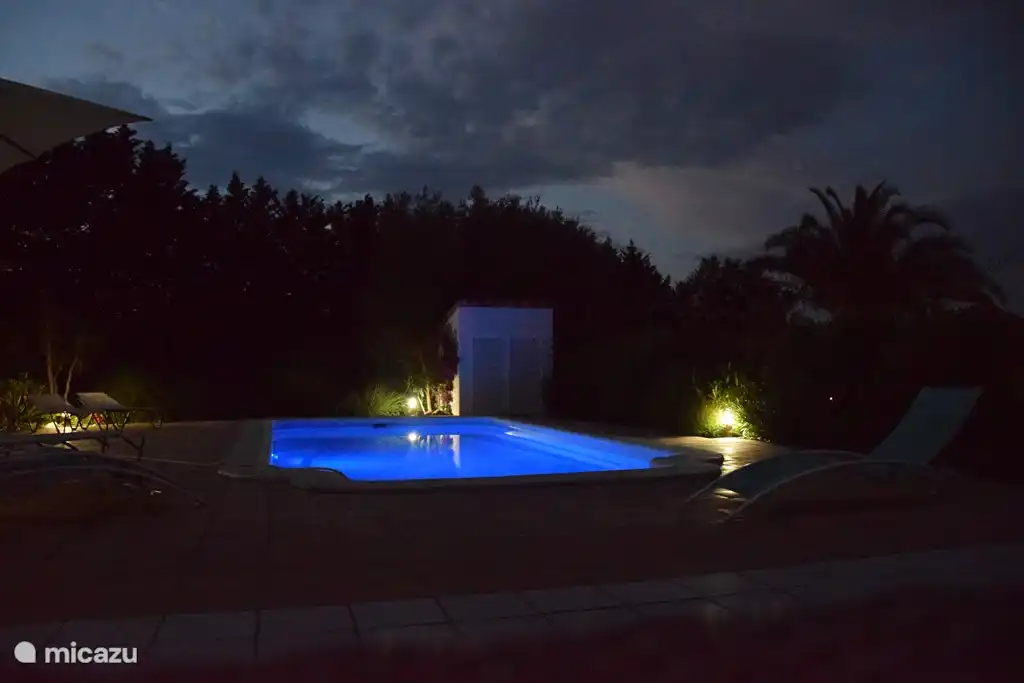 La piscina privada de noche, iluminada por una l&#225;mpara LED con un esquema de color ajustable