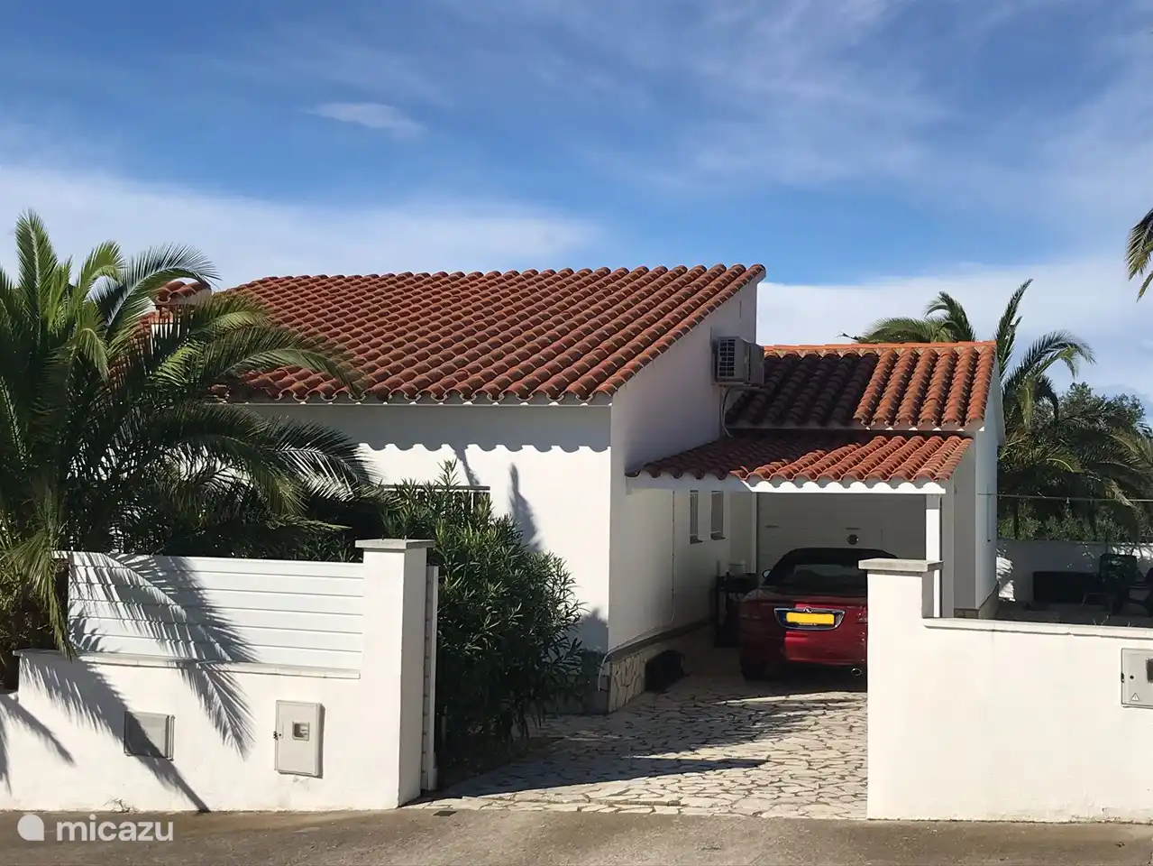 Vorderansicht mit Parkmöglichkeiten vor Ort hinter automatisch verschließbarem Tor.