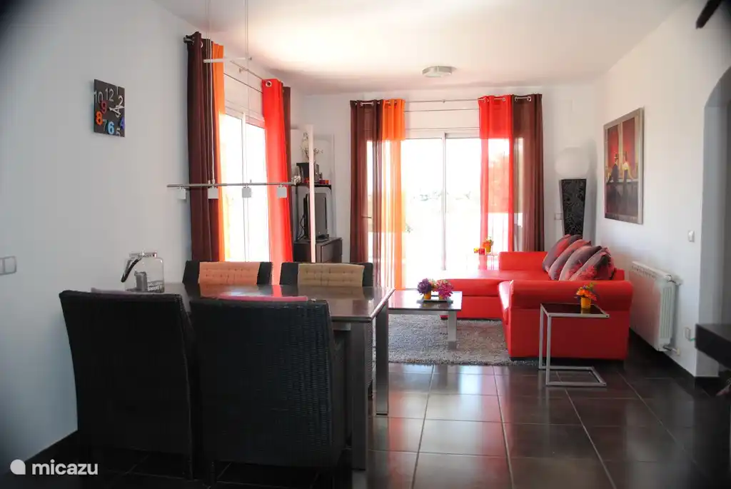 Übersicht Wohnzimmer mit Türen zur überdachten Terrasse Schiebetüren Blick auf den Pool.