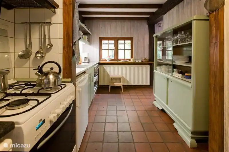 Küche mit großem Kühlschrank mit Gefrierfach, Herd mit Backofen, Geschirrspüler, Waschmaschine und Trockner. Hier finden Sie eine umfangreiche Küchenausstattung, von der Küchenmaschine bis zum Apfelentkerner.