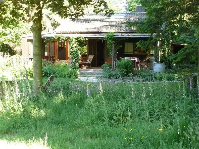 Das Haus im Sommer. Einige Stücke Grünland sind mit wilden Blumen gesät. Jedes Jahr ist es spannend zu sehen, was dabei rauskommt.