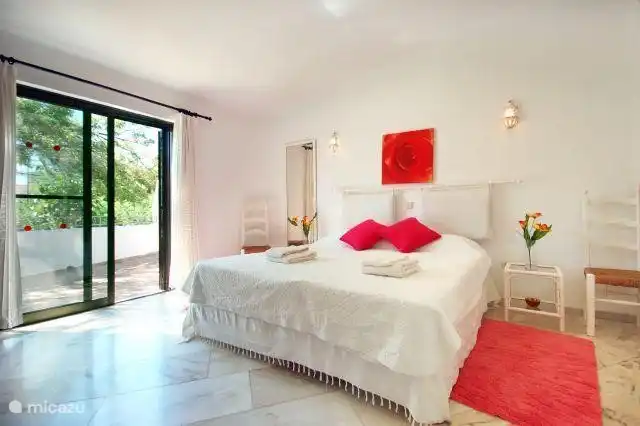 Schlafzimmer 1 mit Doppelbett in Boxspring 180 x 200 cm und Terrassentüren nach draußen.