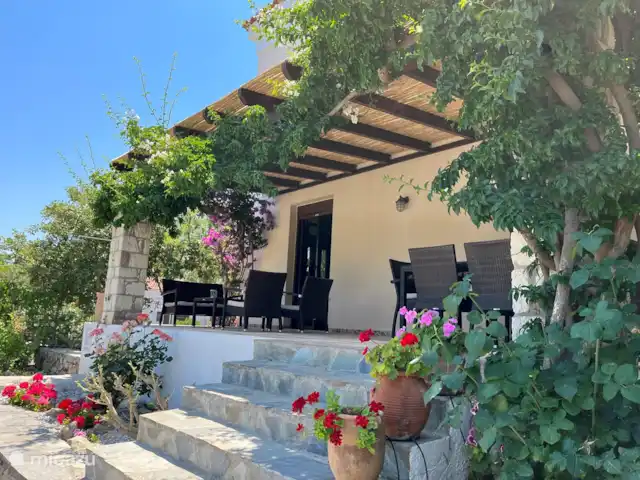 Location de Vacances Grèce, Crète, Rethymnon, villa - Villa Zeus Prinès Véranda spacieuse avec table à manger avec six chaises et salon avec toujours de l'ombre.