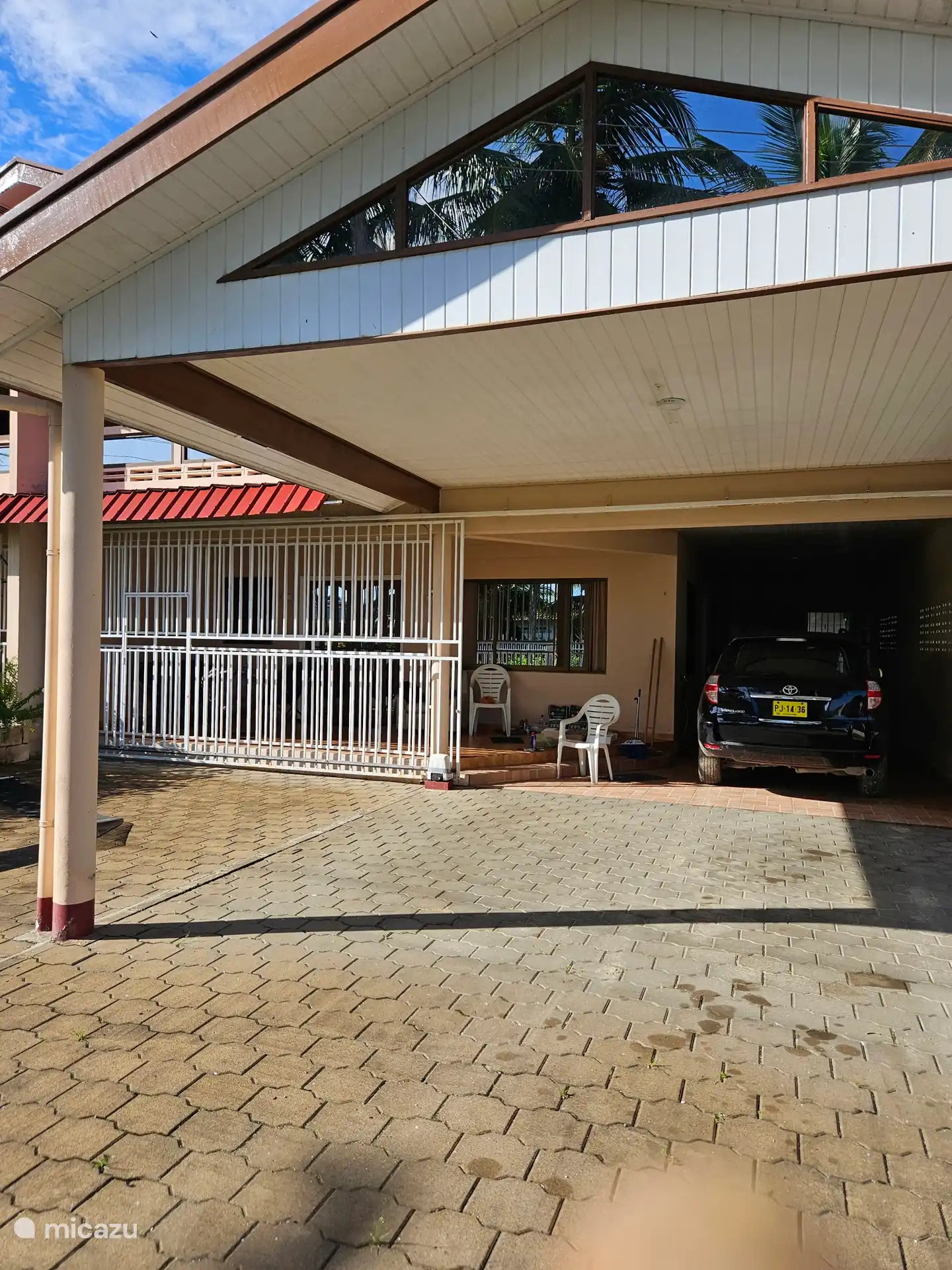 Abri voiture avec accès à la maison et au garage.