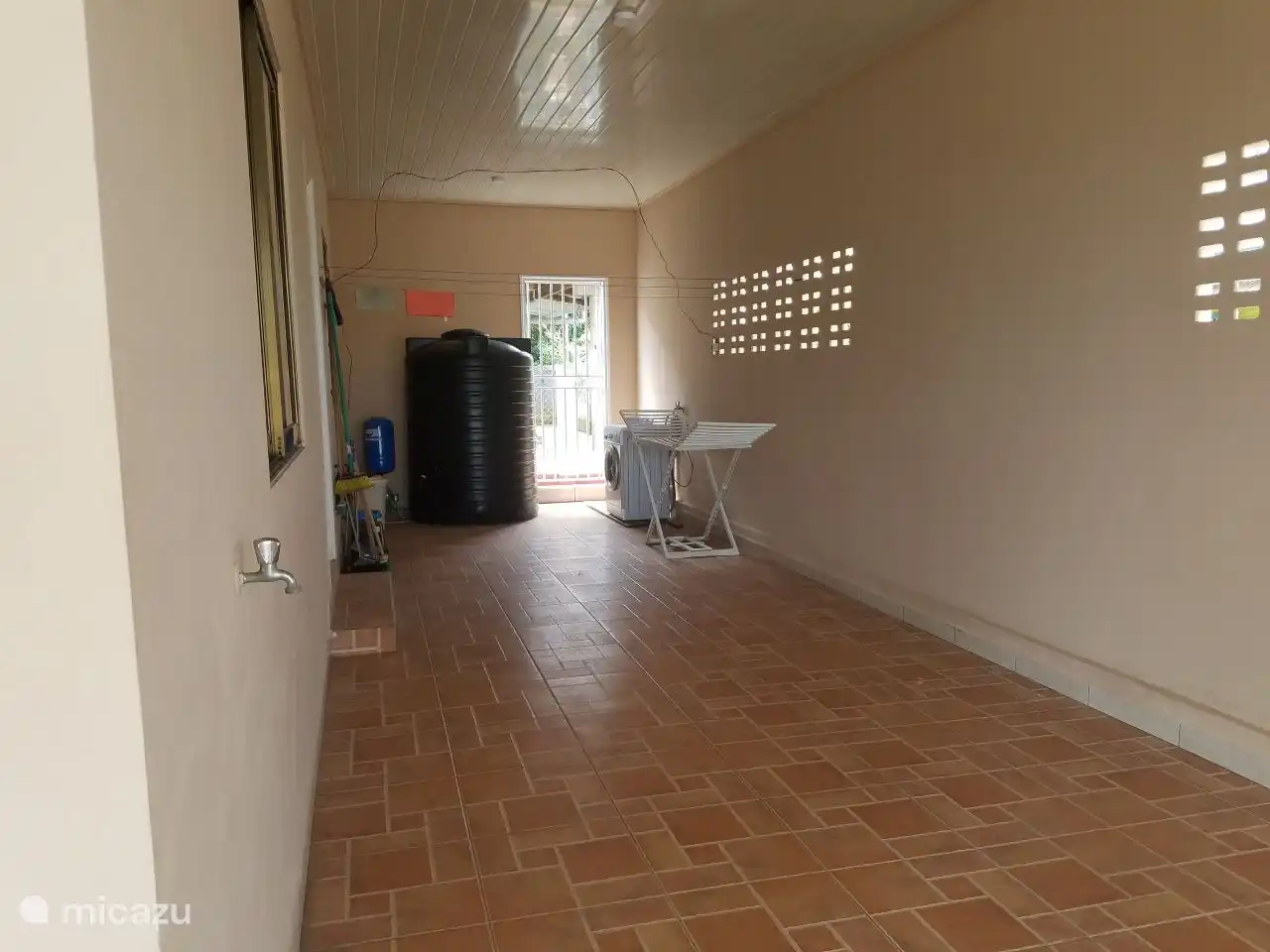 Garage d'une profondeur d'environ 10m. En arrière-plan un réservoir d'eau et un séchoir