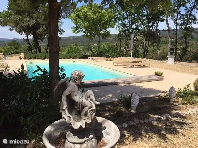 El amplio jard&#237;n tiene una hermosa piscina climatizada con tumbonas con colchonetas alrededor de la terraza.