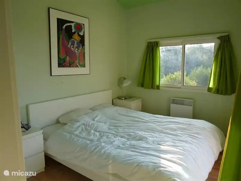 La chambre principale, au rez-de-chaussée, donne sur le lac et la terrasse et a des portes coulissantes sur la terrasse. Tout vert pomme ou bambou, aussi les murs et le plafond, très gai.