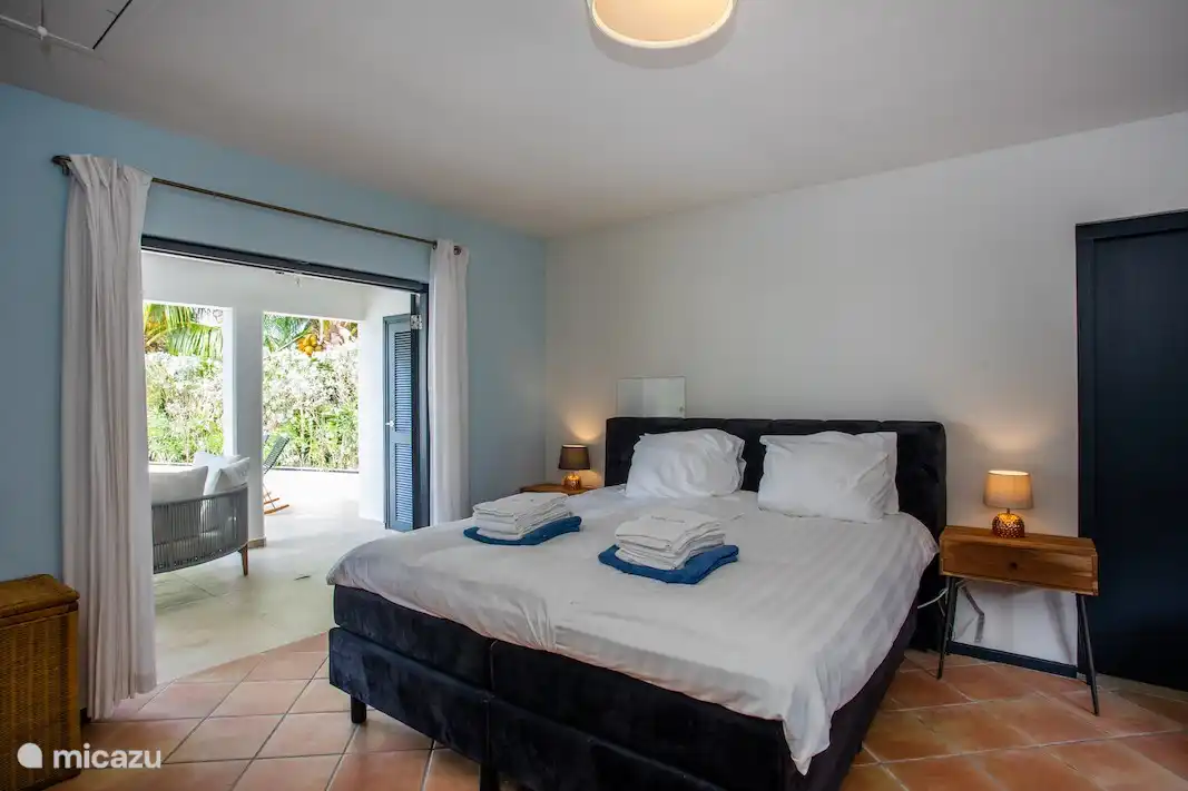 La grande chambre principale a une salle de bain privée. De cette chambre, vous avez un accès direct au porche et à la piscine par des portes-fenêtres.