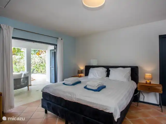 Villa salsa | Curaçao, Banda Ariba (est), Spaanse Water - villa La grande chambre principale a une salle de bain privée. De cette chambre, vous avez un accès direct au porche et à la piscine par des portes-fenêtres.