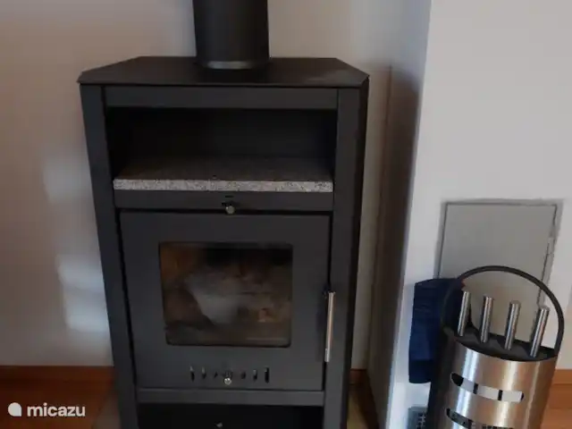chalet en Austria, Carintia, Kötschach-Mauthen – casa de campo La estufa de leña en la sala de estar crea ambiente.