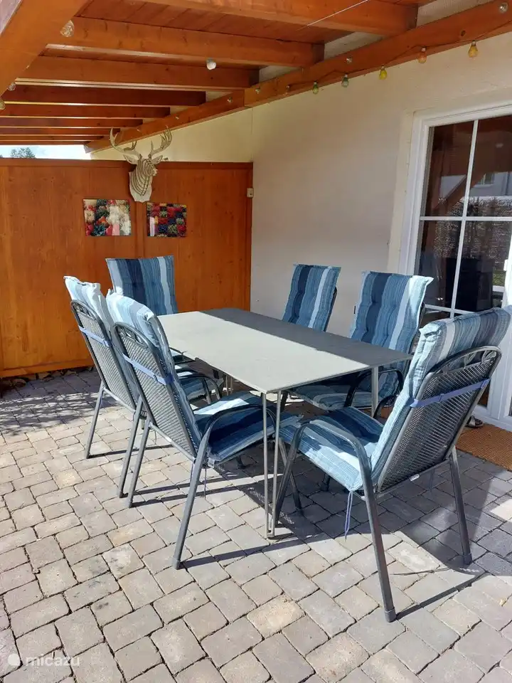 Coin repas sur la terrasse couverte.