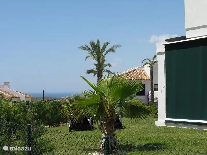 Tuin met zeezicht en luifel aan zijkant terras. Dit zorgt voor een heerlijk beschut terras wanneer u maar wilt. 