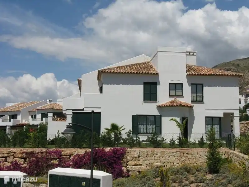 Zijkant huis met fraaie bougainville tegen de muur. 