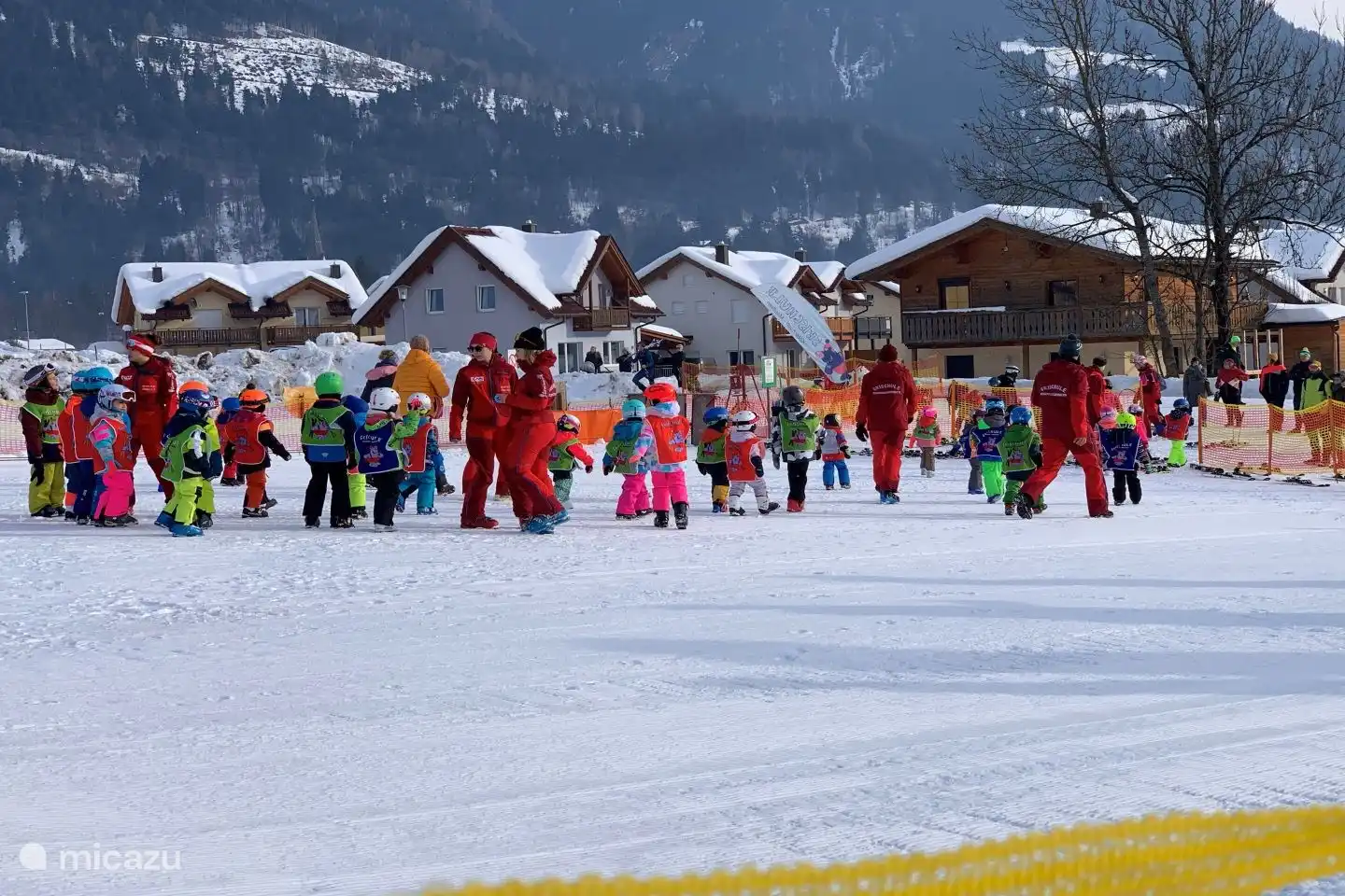 Warm up children hand in hand with music before the ski lessons start.