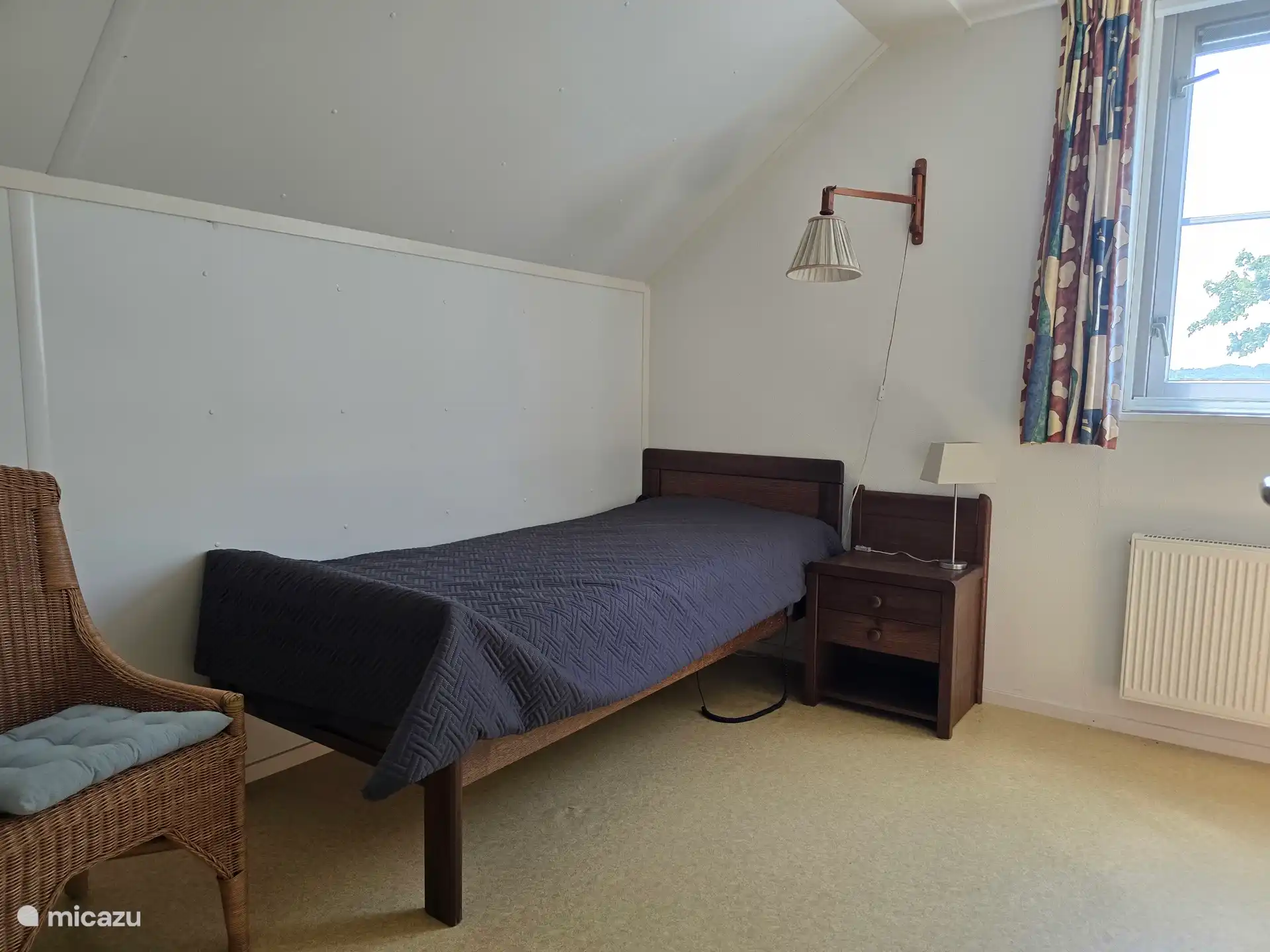 Schlafzimmer im ersten Stock im Südwesten mit 1-Personen-Bett mit elektrisch verstellbarem Boden und geräumigem Kleiderschrank. Schlafzimmerfenster mit Rollgitter.