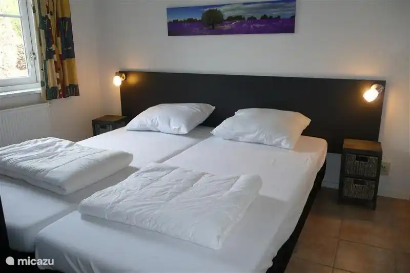 Schlafzimmer im Erdgeschoss mit zwei Boxspringbetten 90 x 200 mit Bettdecke, Nachttischen und Leselampen. Großer Kleiderschrank im Schlafzimmer. Fliesenboden. Fenster mit Insektenschutz gegen Fliegen.