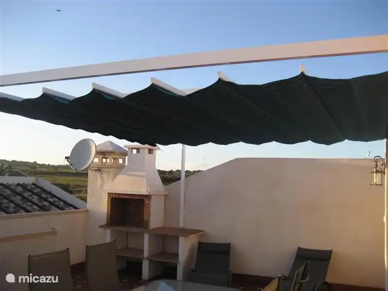 Si vous voulez échapper aux rayons du soleil pendant un moment, vous pouvez étendre le pare-soleil sur la terrasse sur le toit.