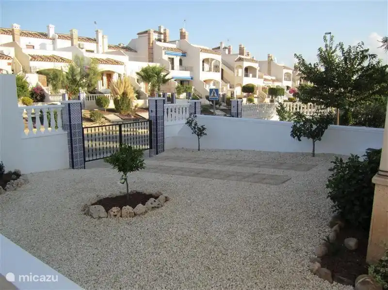 Derrière la maison se trouve le jardin, avec une place de parking pour la voiture.