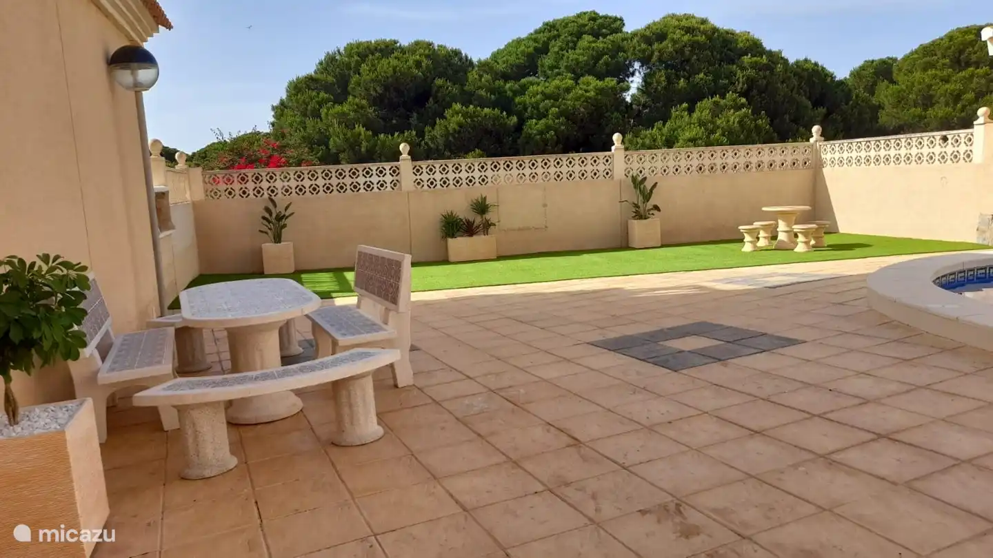 Maintenant aussi à la piscine un joli coin salon avec de l'herbe et des sièges. Il a l'air très confortable.