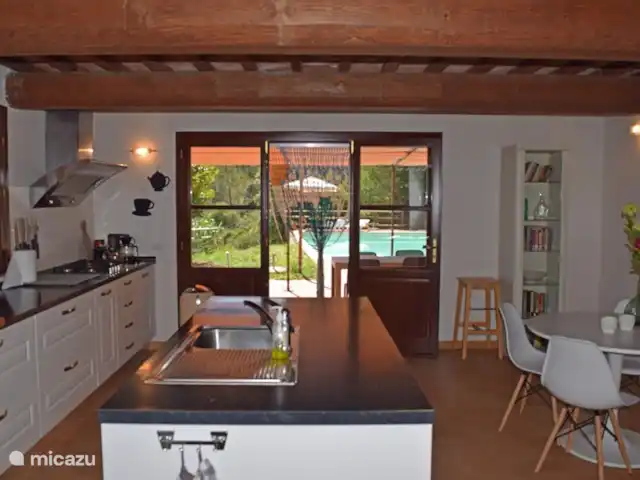 Casa al Pino | Italie, Toscane, Riparbella - maison de vacances Casa al Pino dispose d'une cuisine entièrement équipée avec îlot, d'une petite table à manger pour le petit-déjeuner et de portes-fenêtres donnant sur la terrasse et la piscine.