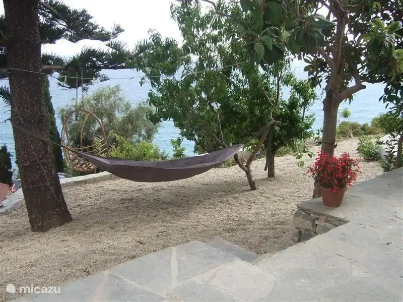 le grand hamac fatboy est suspendu à l'ombre des arbres.