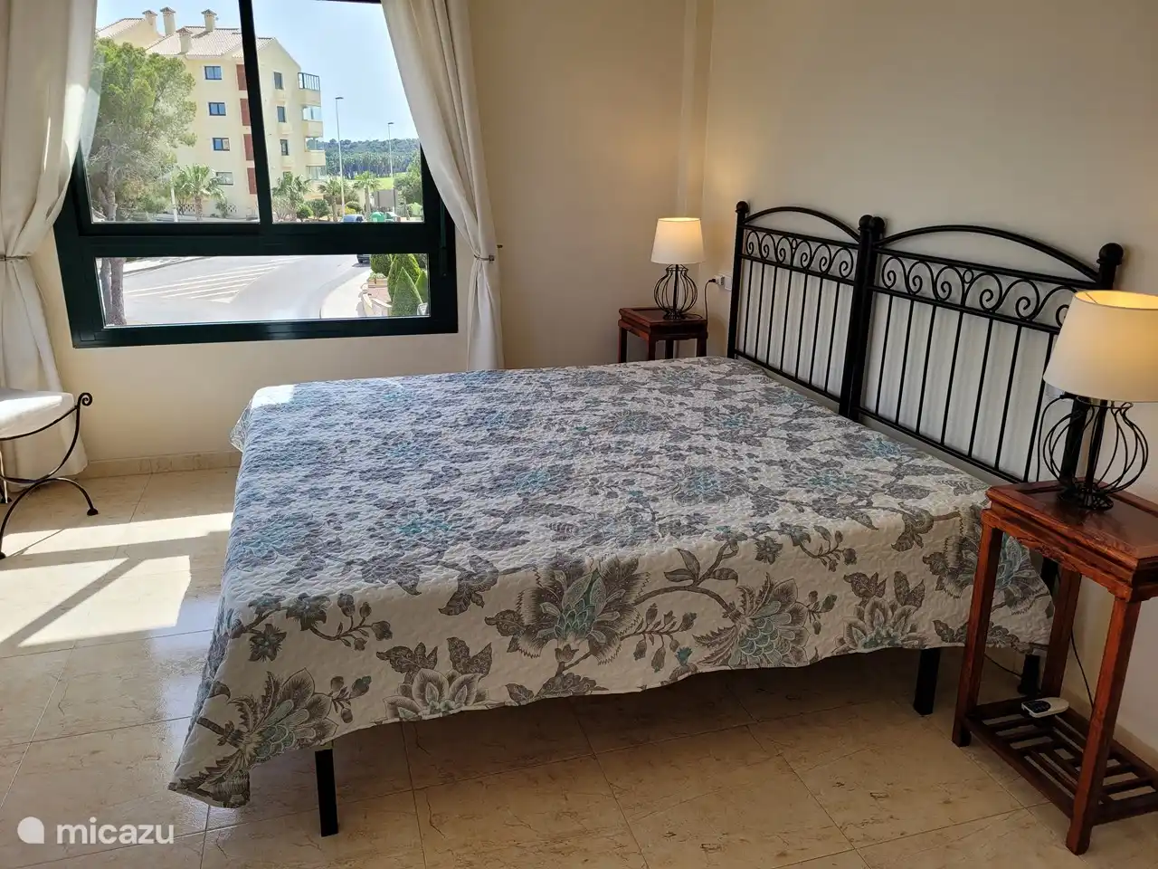 Chambre des maîtres avec placard et salle de bain avec baignoire, douche séparée, toilette et meuble double vasque. Également sur le côté vue vers le terrain de golf.