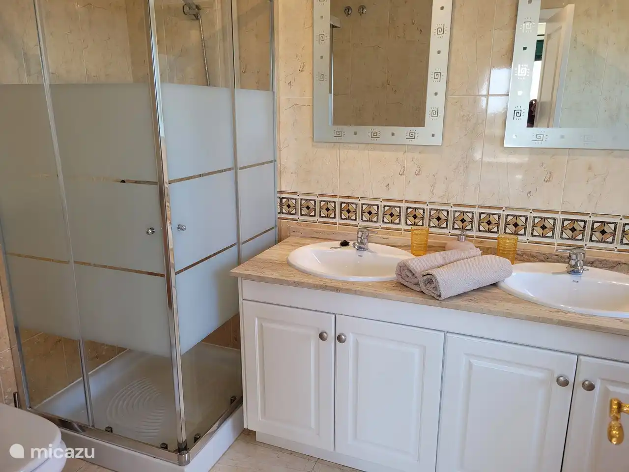 Salle de bain attenante à la chambre principale avec douche spacieuse, toilettes, double vasque et baignoire