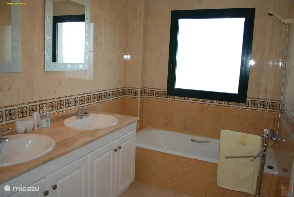 Le bain dans cette salle de bain avec fenêtre qui s'ouvre.