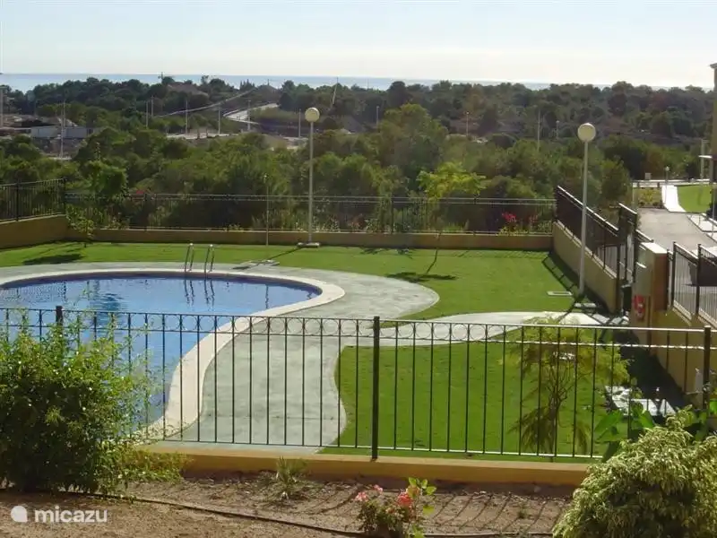 La piscine communale des 'Aigles'. Des parasols fixes en chaume et des transats sont disponibles autour de la piscine.