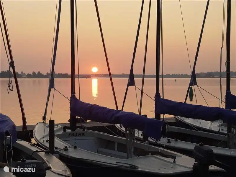 Untergehende Sonne entlang den Booten und dem Wasser spazieren.